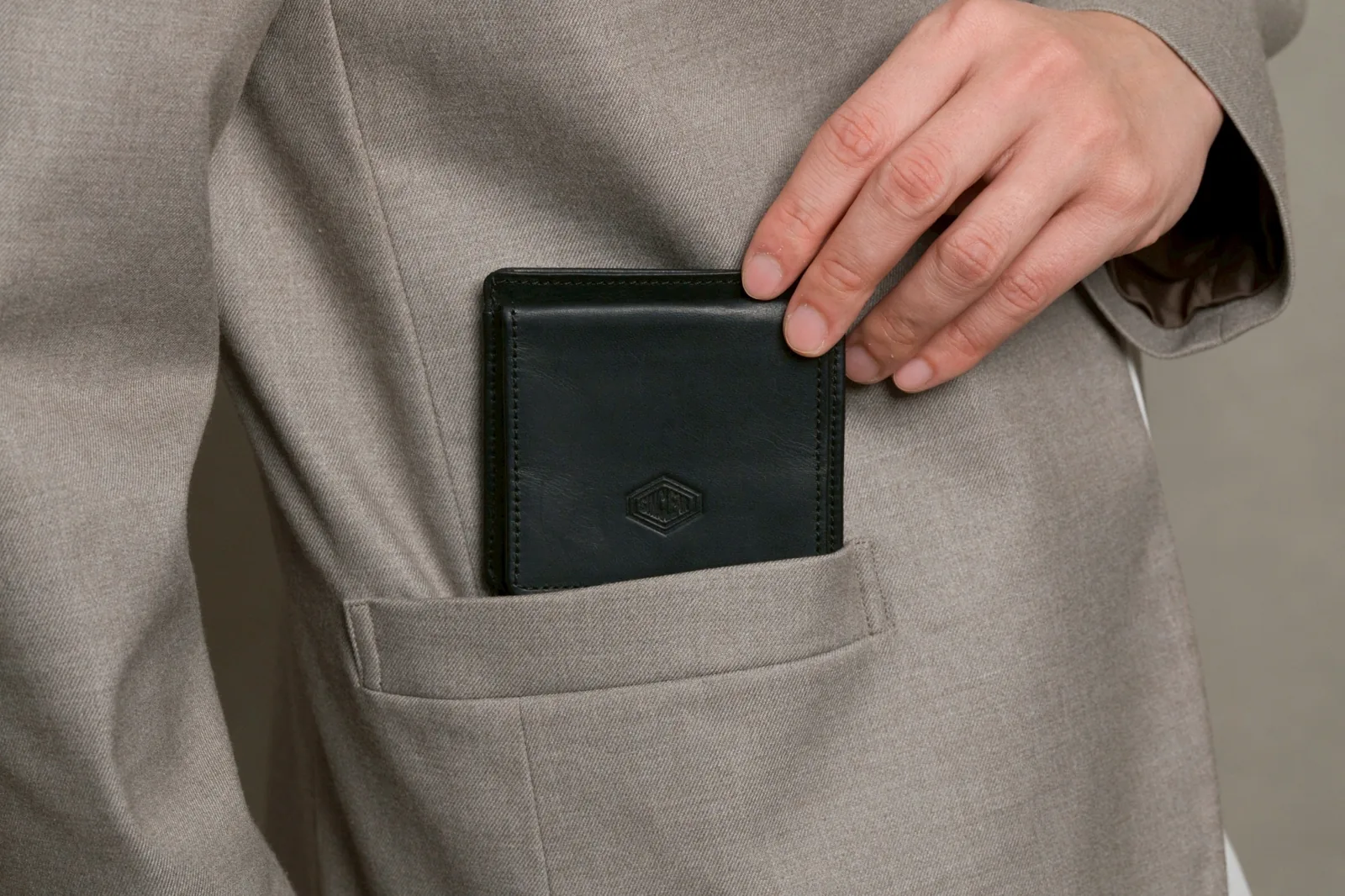 ジャケットのポケットにCompact Walletを入れるところ