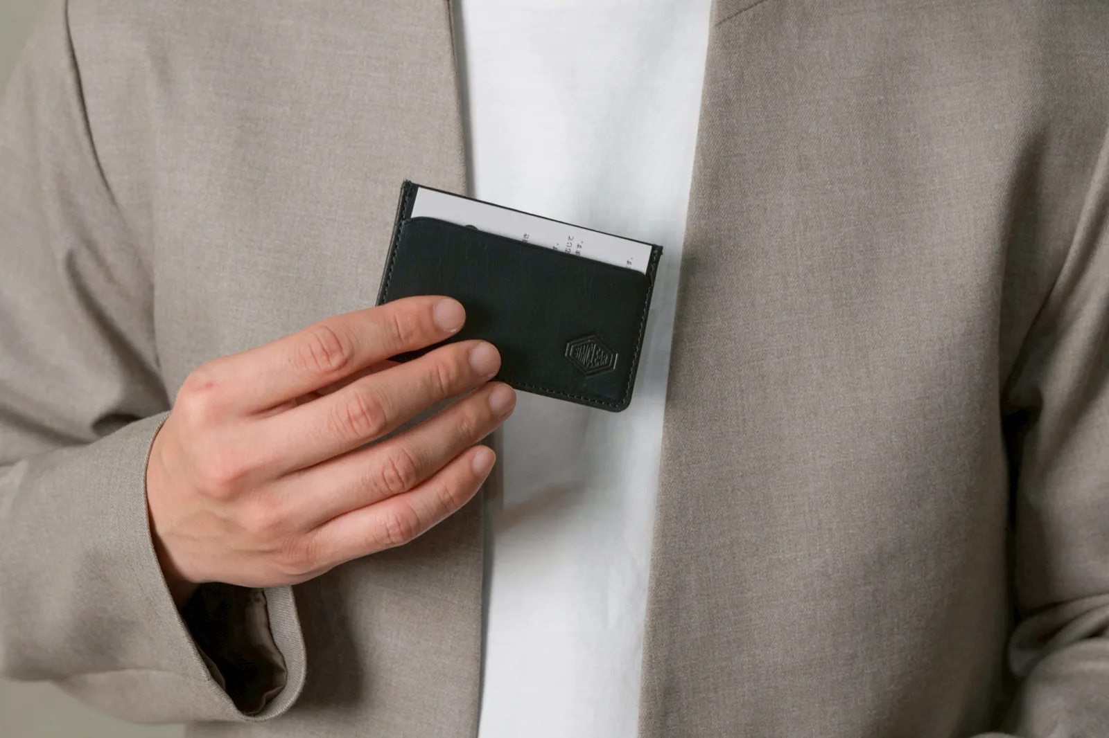 ジャケットの胸ポケットにSlim Card Caseを入れるところ