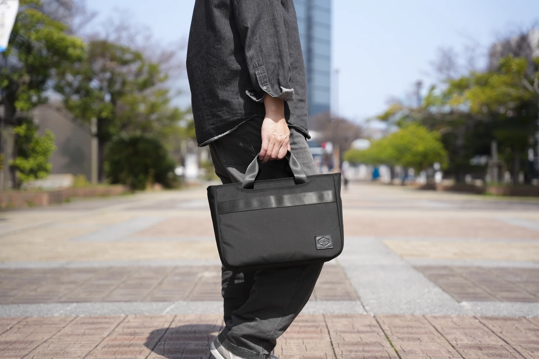 BLACKを手持ちで提げて街を歩く着用イメージ